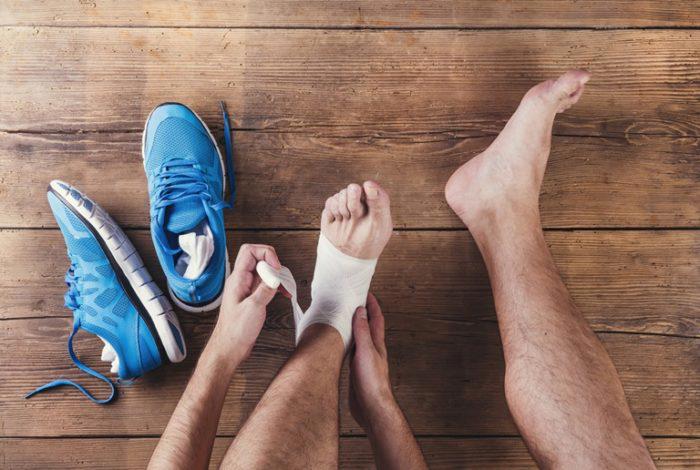 Injured Runner applying bandage to foot