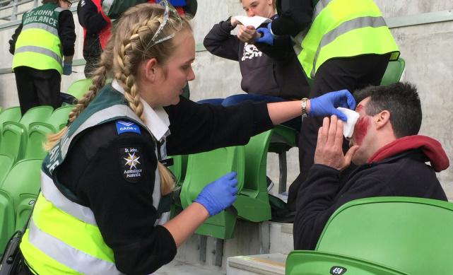 st john volunteer applying first aid to man